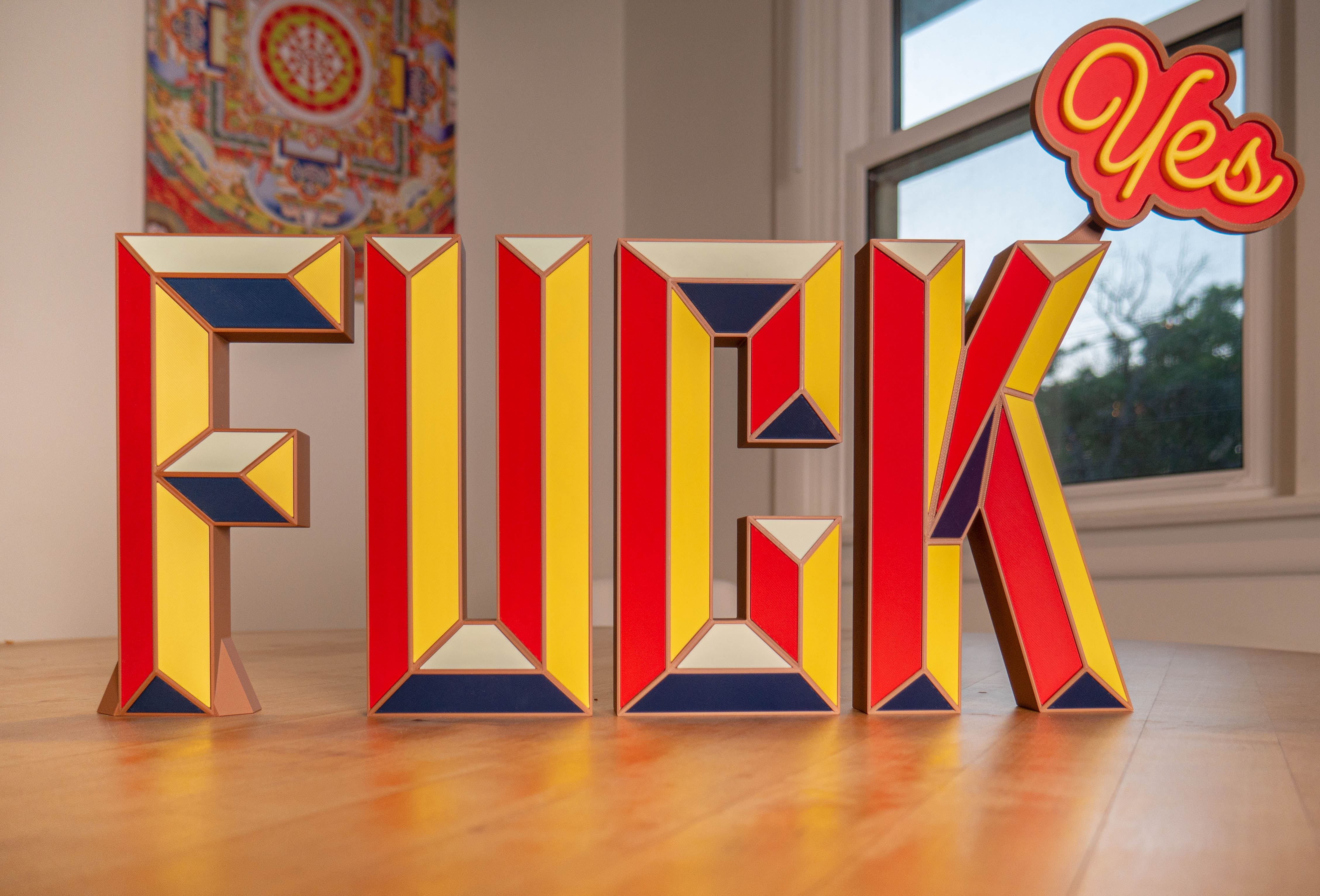 FUCK desk sculpture in a home setting with YES accessory